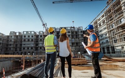 Fachleute im Gespräch vor einem Neubaukomplex